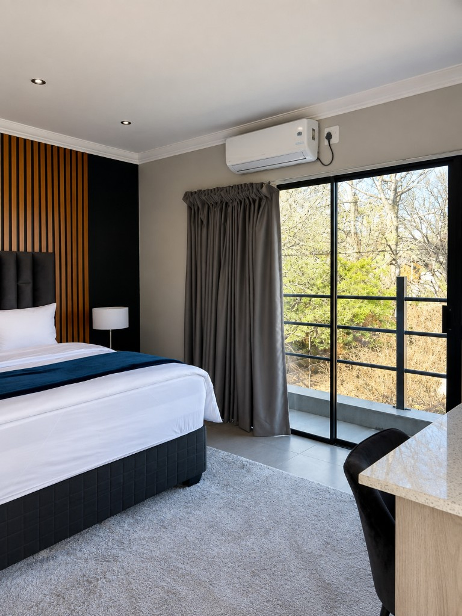 Bedroom with navy runner and wood-slat feature wall