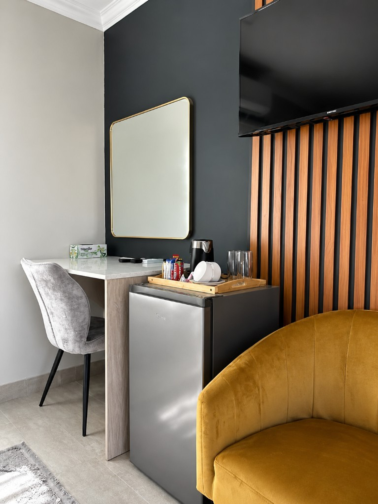 Guest desk, mirror, and tea station with mustard armchair